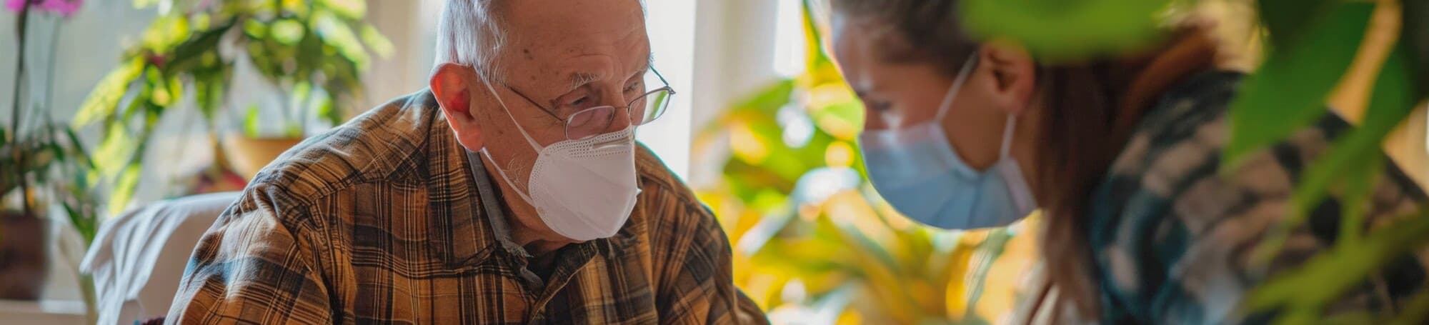 Older man and a caregiver, both wearing masks