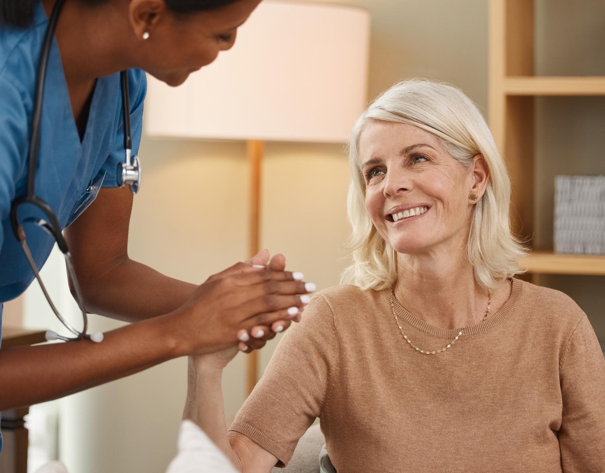 Nurse holding the hands of a smiling patient