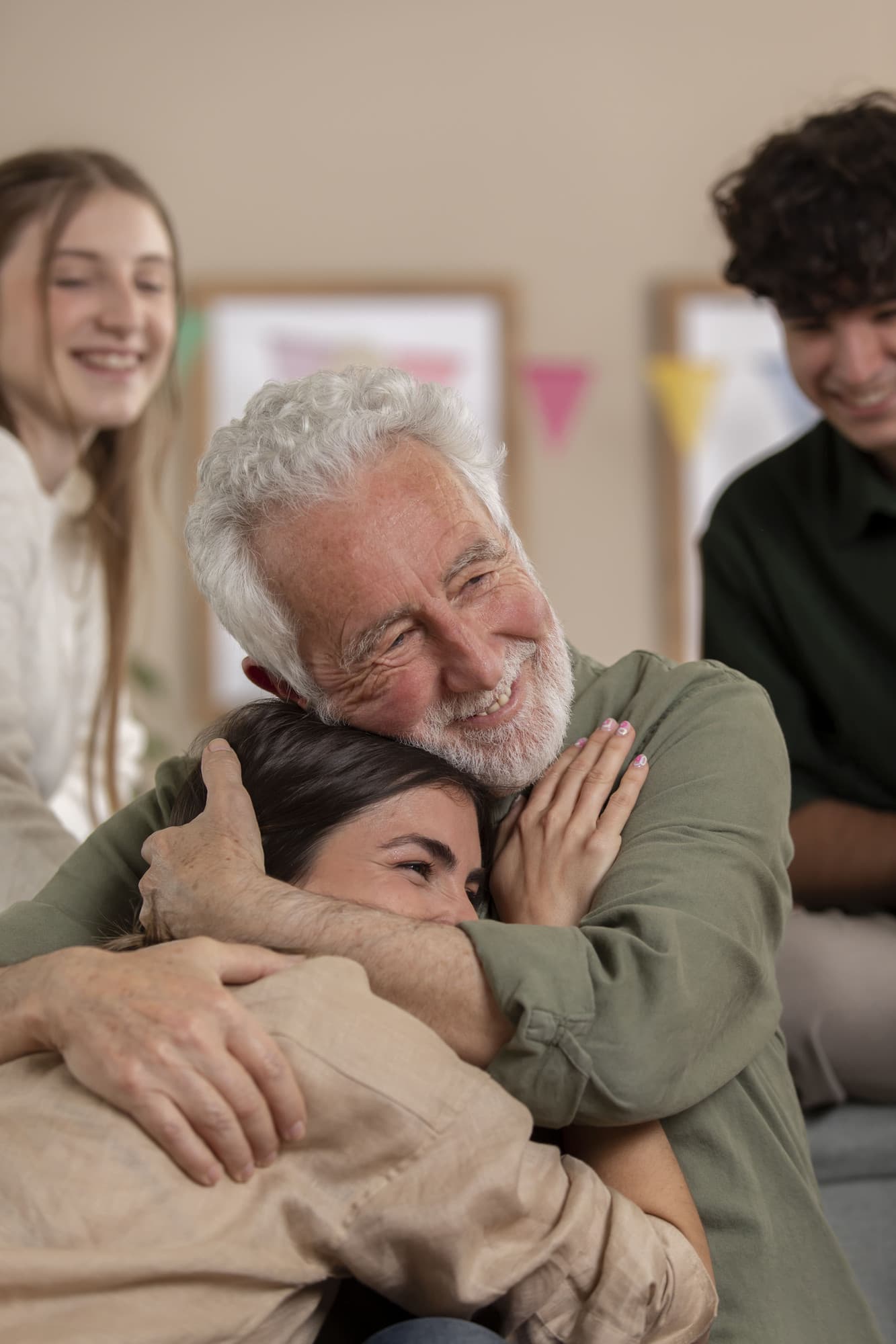 Grandfather hugging his family at home