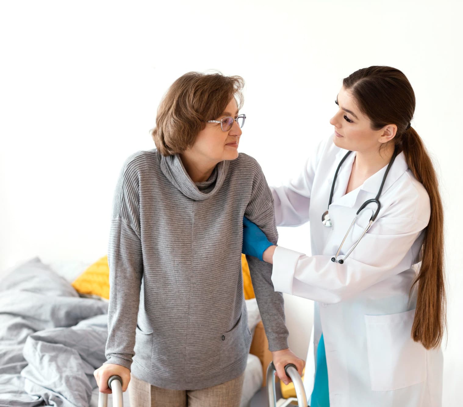 Physician helping an older woman walk with a walker