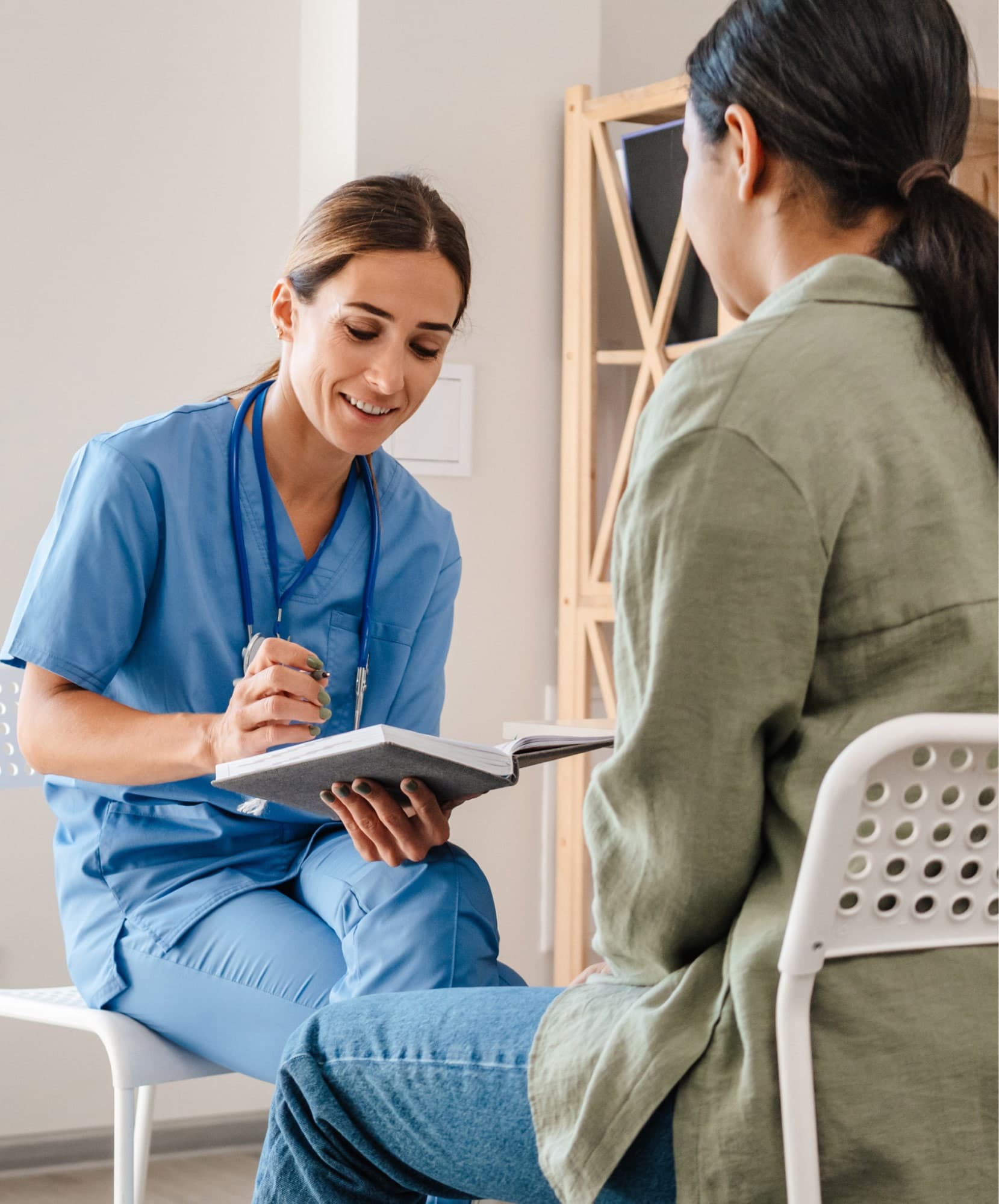 Nurse taking notes while talking with a patient