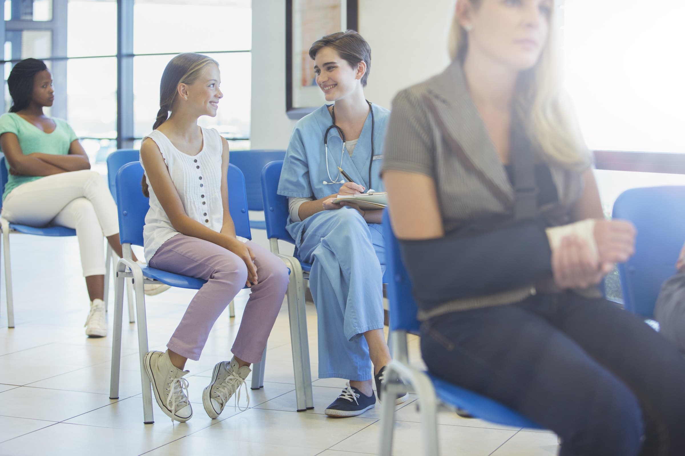 Nurse talking with patients in a clinic waiting room